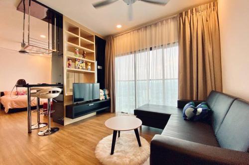 a living room with a couch and a table and a television at Landmark Residence 1, Pool View, Free WiFi, TV-box, Free Parking, Near Kajang, Mahkota Cheras, C180, MRT in Kajang