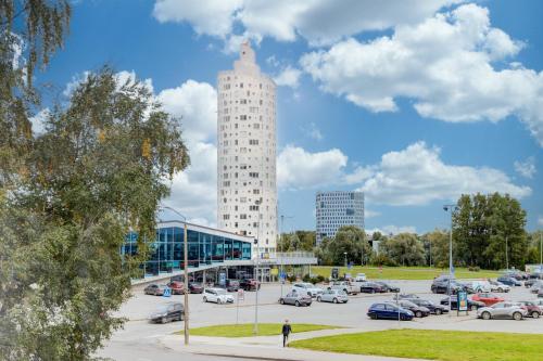 a parking lot with a tall building in the background at Aura, City Center, Tartu Home in Tartu