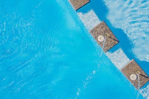 an overhead view of a pool with blue water at Ville D'Ogliastra in Cardedu