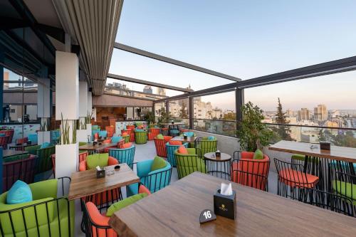 a view of a restaurant with tables and chairs at Coral Tower Hotel by Hansa in Amman