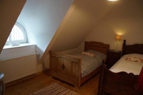 a attic room with two beds and a window at Kreativ-Kate in Kranenburg