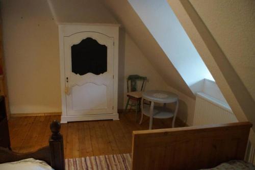 an attic room with a white door and a table at Kreativ-Kate in Kranenburg
