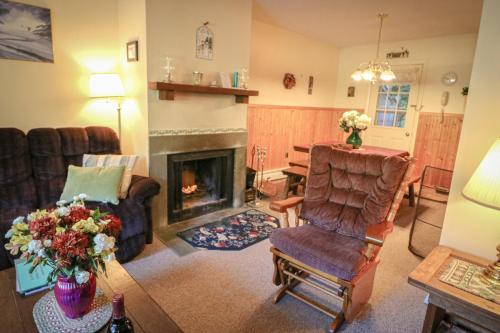 - un salon avec une chaise et une cheminée dans l'établissement Quaint Condo 5 minutes to the ski slopes Valley Park D1, à Killington