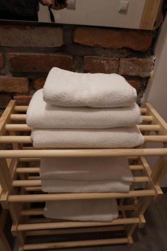 a stack of white towels on a wooden shelf at Centrum Łąkowa 1 in Wünschelburg