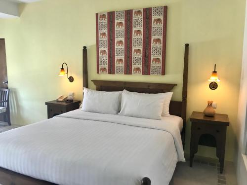 ein Schlafzimmer mit einem großen weißen Bett mit zwei Nachttischen in der Unterkunft Ao Nang Colors Hotel - Aonang Beach in Ao Nang Beach