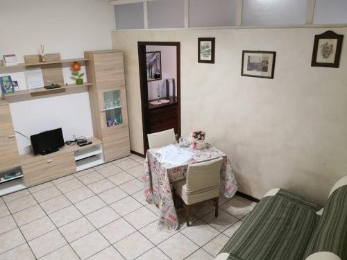 een woonkamer met een tafel en een televisie bij Appartamento da Raffaella CIR O12133 CNI OOO39 in Varese