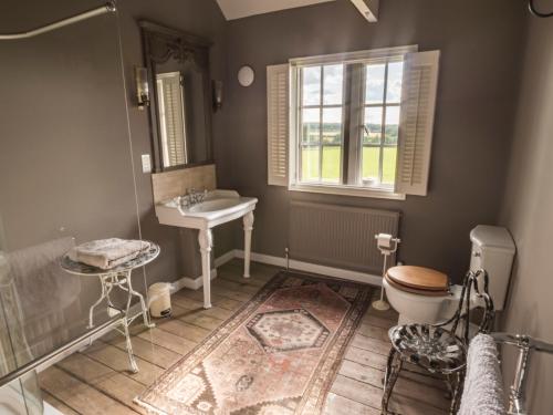 a bathroom with a sink and a toilet and a window at The Delaval Rooms in Lincoln