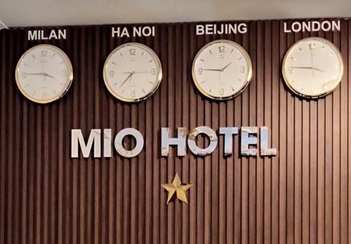 three clocks on the wall of a mlo hotel at Mio Hotel in Hải Dương