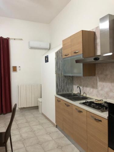 una cucina con lavandino e piano cottura forno superiore di Planet casa vacanze a Montalbano Ionico