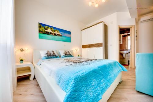 um quarto com uma cama grande e um cobertor azul em Sveti Luka Apartments em Dobra Voda