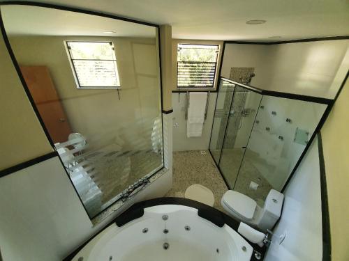 bagno con vasca, doccia e servizi igienici di Pousada Golden Garden a Caxambu