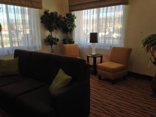a living room with a couch and a chair and windows at Sleep Inn Pelham Oak Mountain in Pelham