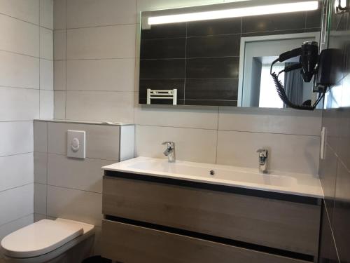 a bathroom with a sink and a toilet and a mirror at nuit sur le pont 3 in Landerneau