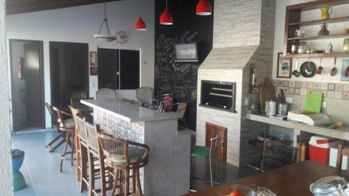 a kitchen with a counter and chairs in a room at Casa Piscina Prainha Caiobá Guaratuba in Matinhos