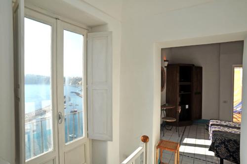 a room with a balcony with a view of the ocean at Hotel La Casa sul Mare in Procida