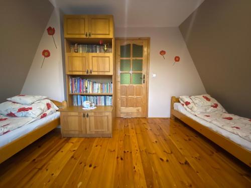 a room with two beds and a book shelf at Dom do wynajęcia "Zawojski Zakątek" in Zawoja