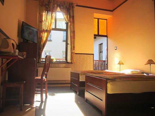 um quarto com uma cama, uma secretária e uma janela em Globtroter Guest House na Cracóvia