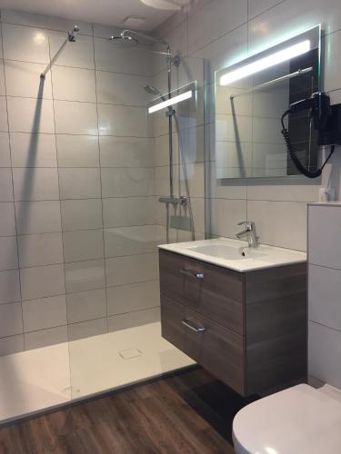 une salle de bain avec un lavabo, des toilettes et un miroir dans l'établissement nuit sur le pont 4, à Landerneau