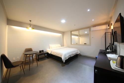 a hotel room with a bed and a table and chairs at VIP Hotel Mokpo in Mokpo