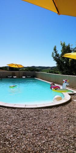 - une piscine avec un bateau à jouets et un parasol dans l'établissement La Tranquillité, Le Repos, à Nanteuil-Auriac-de-Bourzac