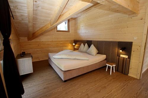 a bedroom with a bed in a wooden cabin at Montana Hochfügen in Hochfugen