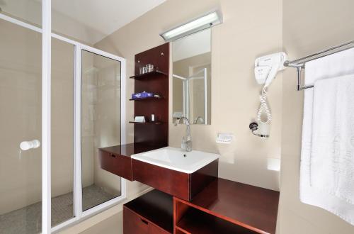 a bathroom with a sink and a mirror at Beach Hotel Swakopmund in Swakopmund