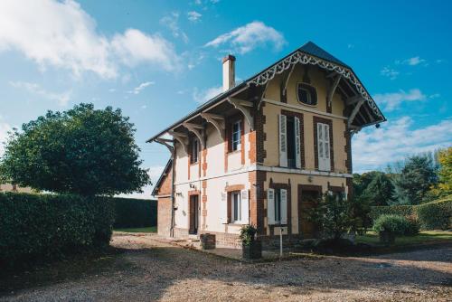 uma casa velha com uma chaminé por cima. em Château du Landin - Bains nordiques em Le Landin