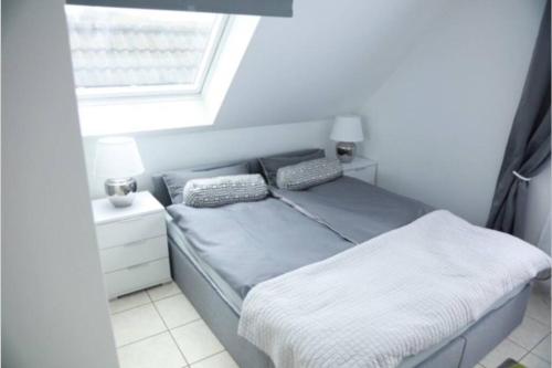 un letto con due cuscini e una finestra in una stanza di Modernes Apartment in Leichlingen a Leichlingen