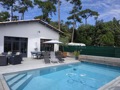 - une piscine avec une terrasse et une maison dans l'établissement Villa Atelier 4****, à Ronce-les-Bains