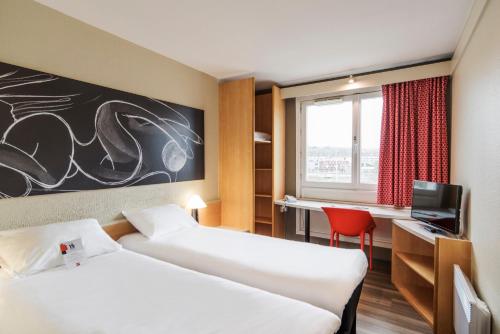een hotelkamer met 2 bedden en een raam bij ibis Boulogne sur Mer Centre les Ports in Boulogne-sur-Mer