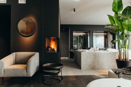 a bathroom with a tub and a chair and a fireplace at Hotel Sanglier in Durbuy
