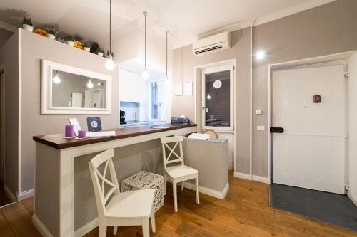 eine Küche mit einer Bar mit 2 Stühlen und einem Tisch in der Unterkunft La Maison di Sant'Anna in Rom