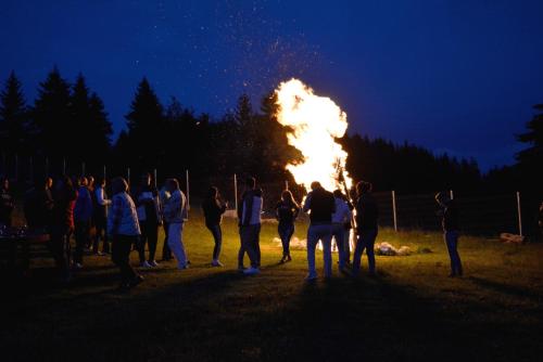 a group of people standing around a fire at Resort EuroPark Fundata in Fundata