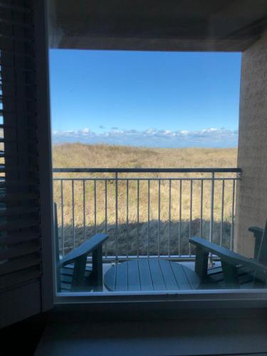 a balcony with a bench and a view of a field at Shutters on the Banks in Kill Devil Hills
