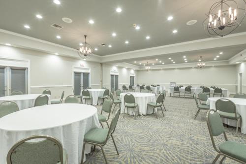 a banquet room with tables and chairs and chandeliers at Best Western Plus St. Simons in Saint Simons Island