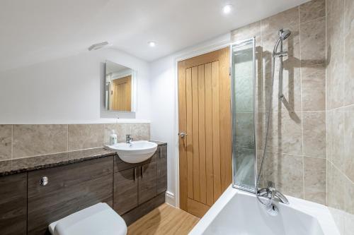 een badkamer met een wastafel en een douche bij Modern & Spacious 2 Bedroom Maisonette in Bath