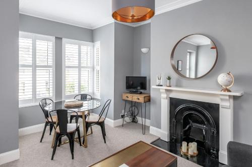 a living room with a table and a mirror at Modern & Spacious 2 Bedroom Maisonette in Bath