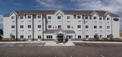 a large white building with a parking lot at Microtel Inn & Suites by Wyndham Loveland in Loveland