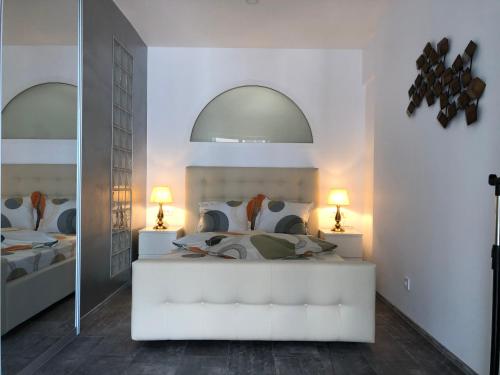een slaapkamer met een bed met 2 lampen en een spiegel bij Luxury Westpark 2 Residence Lake View W6 in Boekarest