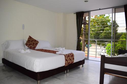 a bedroom with a bed and a large window at Blue Star Hotel in Melgar