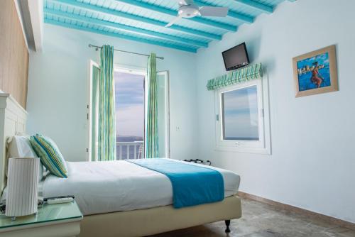 a bedroom with a bed and a window at Poseidon Hotel Suites in Mýkonos City