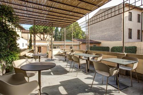 a patio area with tables, chairs and umbrellas at Hotel Orto de' Medici in Florence