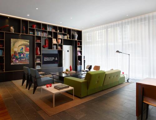a living room with a green couch and a table at citizenM Tower of London in London