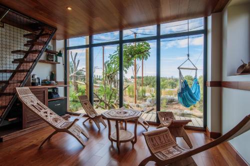 クレシー・ラ・シャペルにあるParrot World - Les Lodgesのテーブルと椅子、大きな窓が備わる客室です。