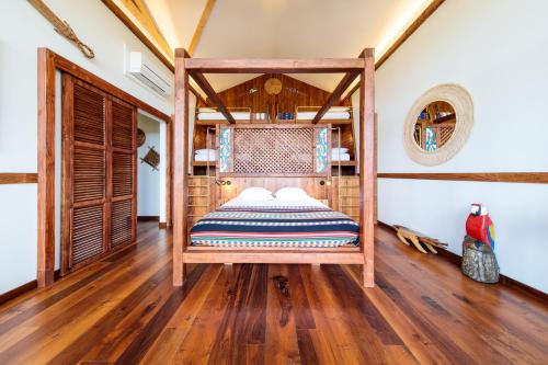 ein Schlafzimmer mit einem Bett in einem Zimmer mit Holzböden in der Unterkunft Parrot World - Les Lodges in Crécy-la-Chapelle