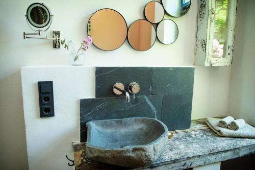 uma casa de banho com um lavatório de pedra e espelhos na parede em Heuerhaus 1898 em Menslage