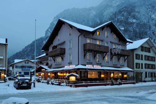 un grand bâtiment avec de la neige dans une rue dans l'établissement Hotel Rössli, à Interlaken