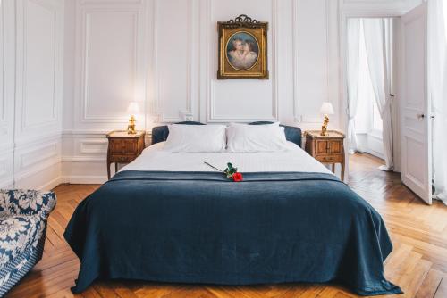 a bedroom with a large bed with a blue blanket at Chateau Du Landin in Le Landin