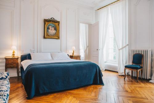 - une chambre blanche avec un lit et une chaise dans l'établissement Chateau Du Landin, à Le Landin