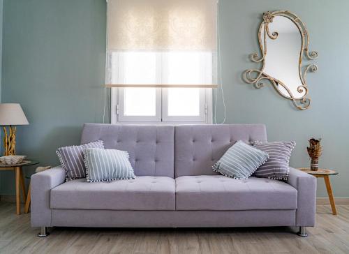 um sofá roxo numa sala de estar com uma janela em Ostraco Syros em Vári